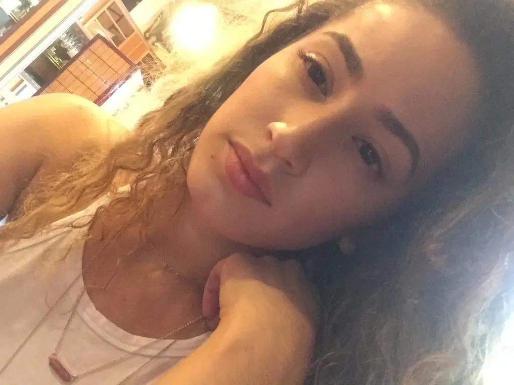 Curly-haired amateur shows off her breasts in selfie
