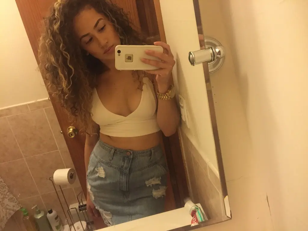 Curly-haired amateur shows off her breasts in selfie