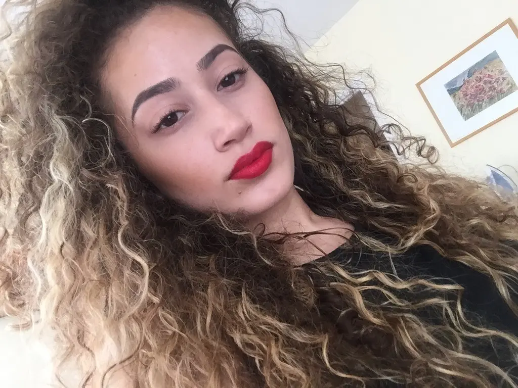 Curly-haired amateur shows off her breasts in selfie